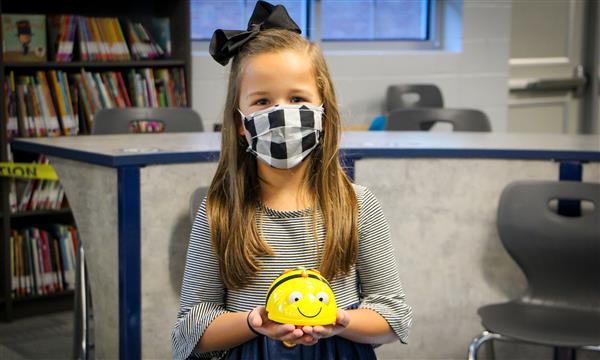 Girl smiles while holding BeeBot